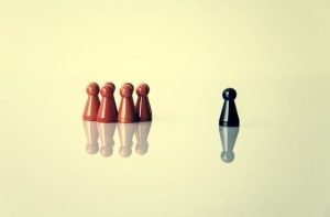 6 rote Spielsteine ein schwarze Spielstein - Othering-Ausgrenzung