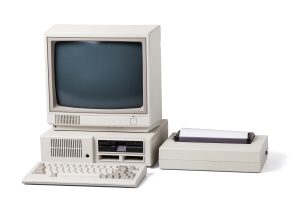 Alter Computer mit Diskettenlaufwerk, Monitor und Drucker auf weißem Hintergrund