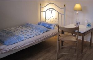 Zimmer mit Bett, Tisch, Stuhl