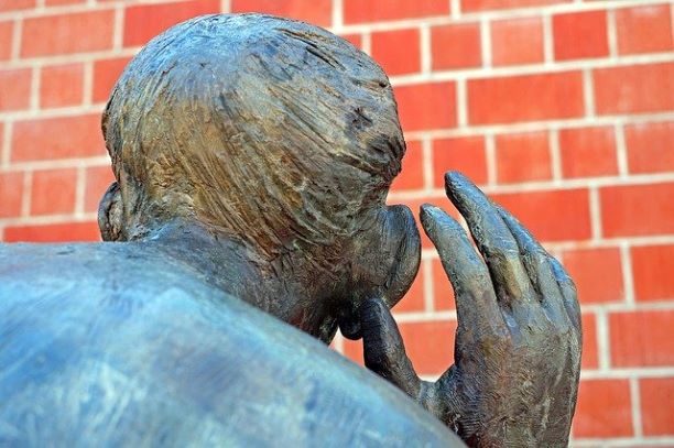Skulptur mit Hand an Ohr